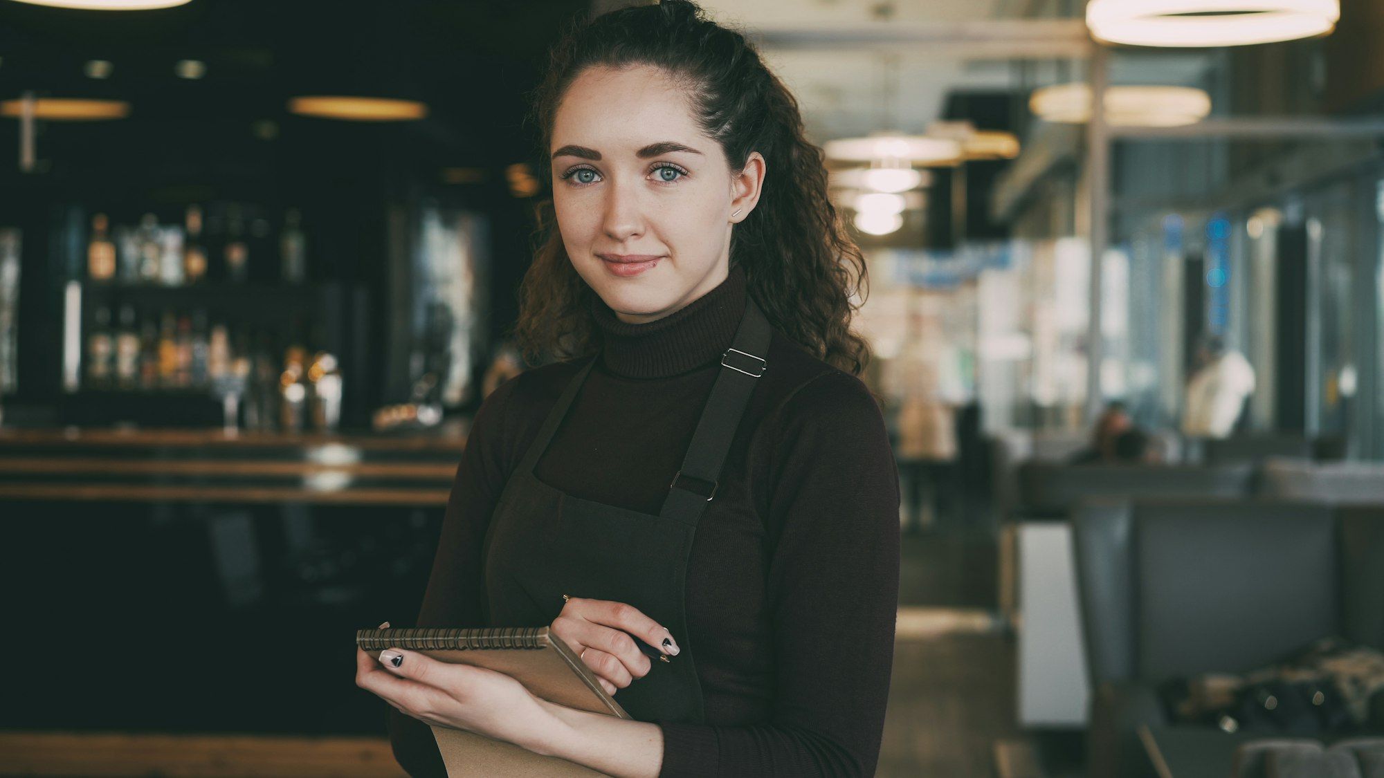 Une restauratrice prend des notes dans sa salle